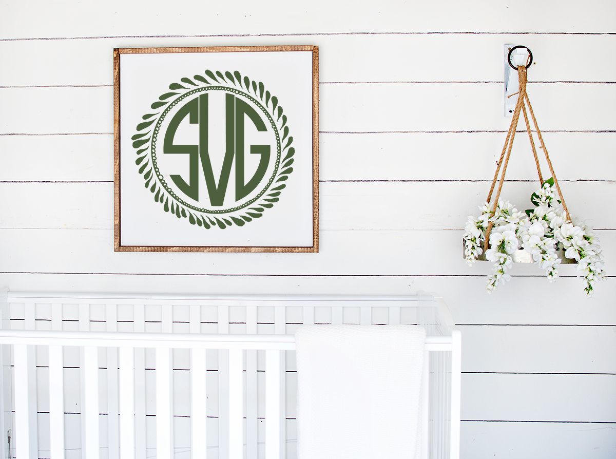 monogram wreath framed  above a  white crib
